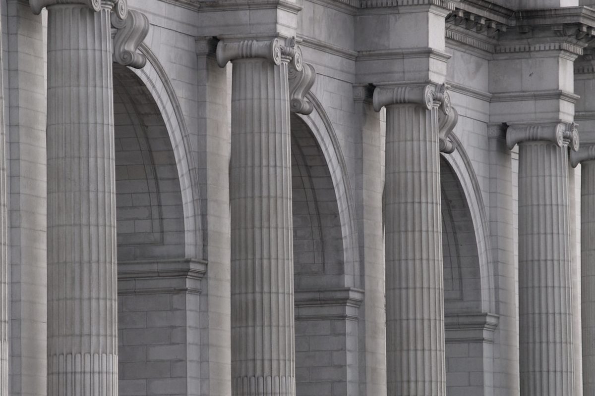 A stone colonnade of columns and arches