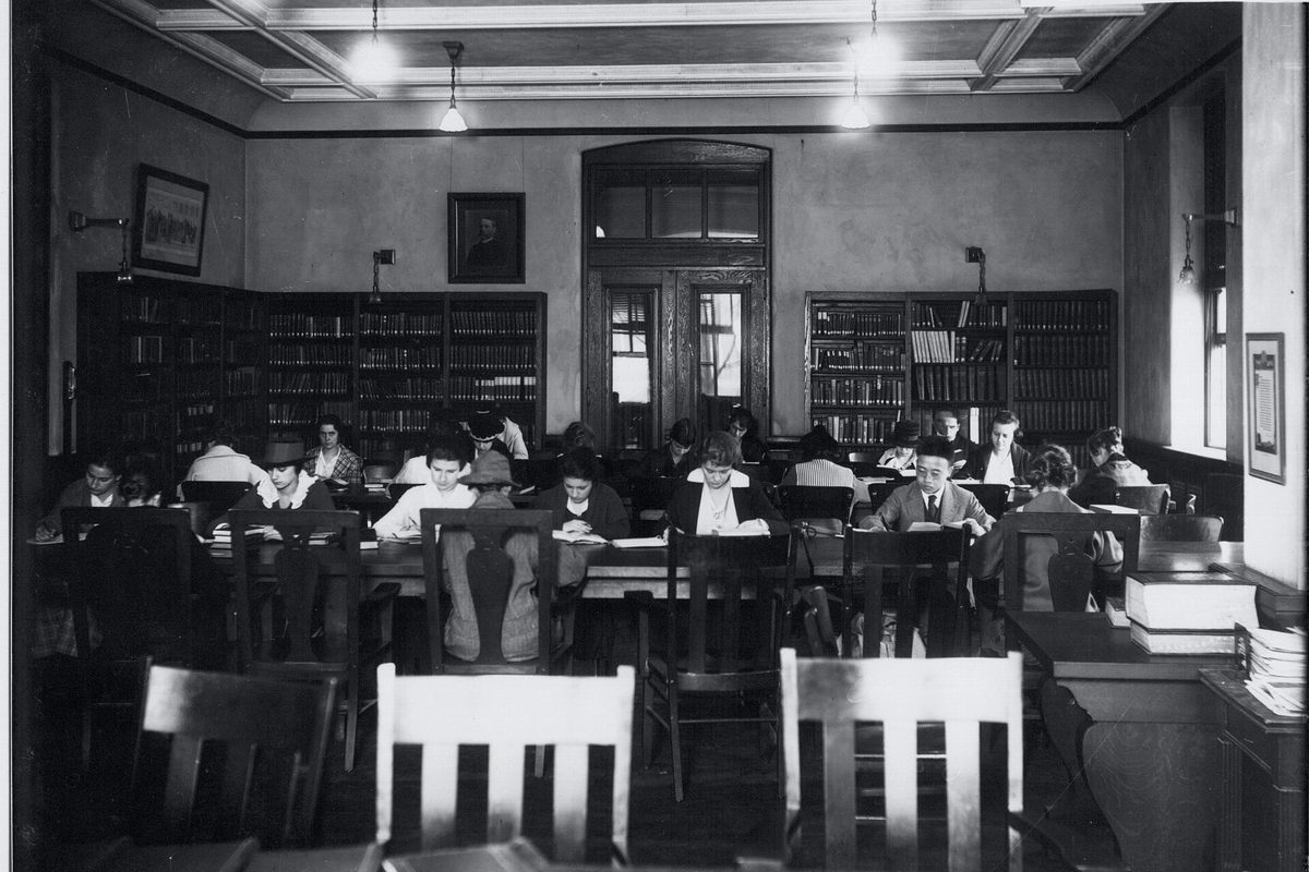 A records reading room lined with shelved volumes
