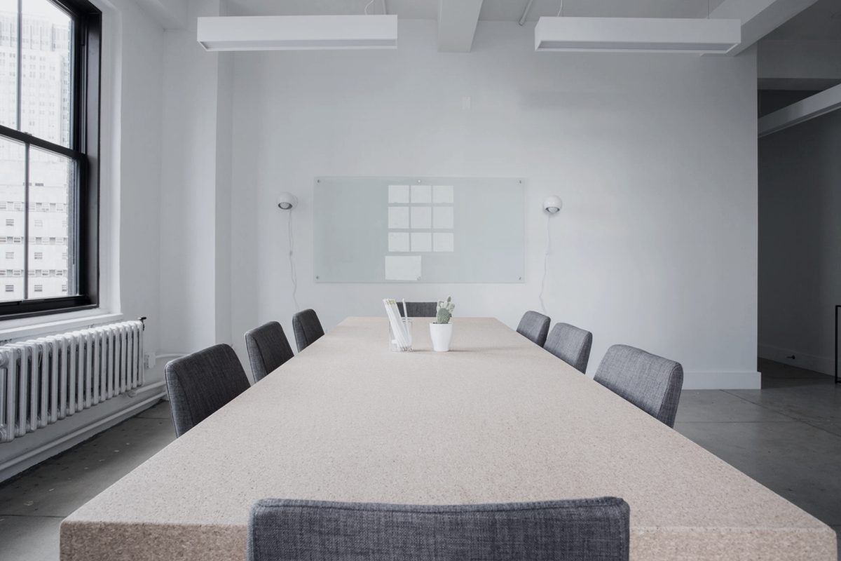 An empty deposition suite with a long conference table set for a proceeding