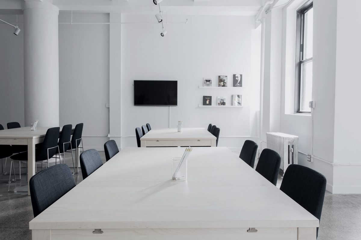A bright meeting room arranged for a hybrid proceeding