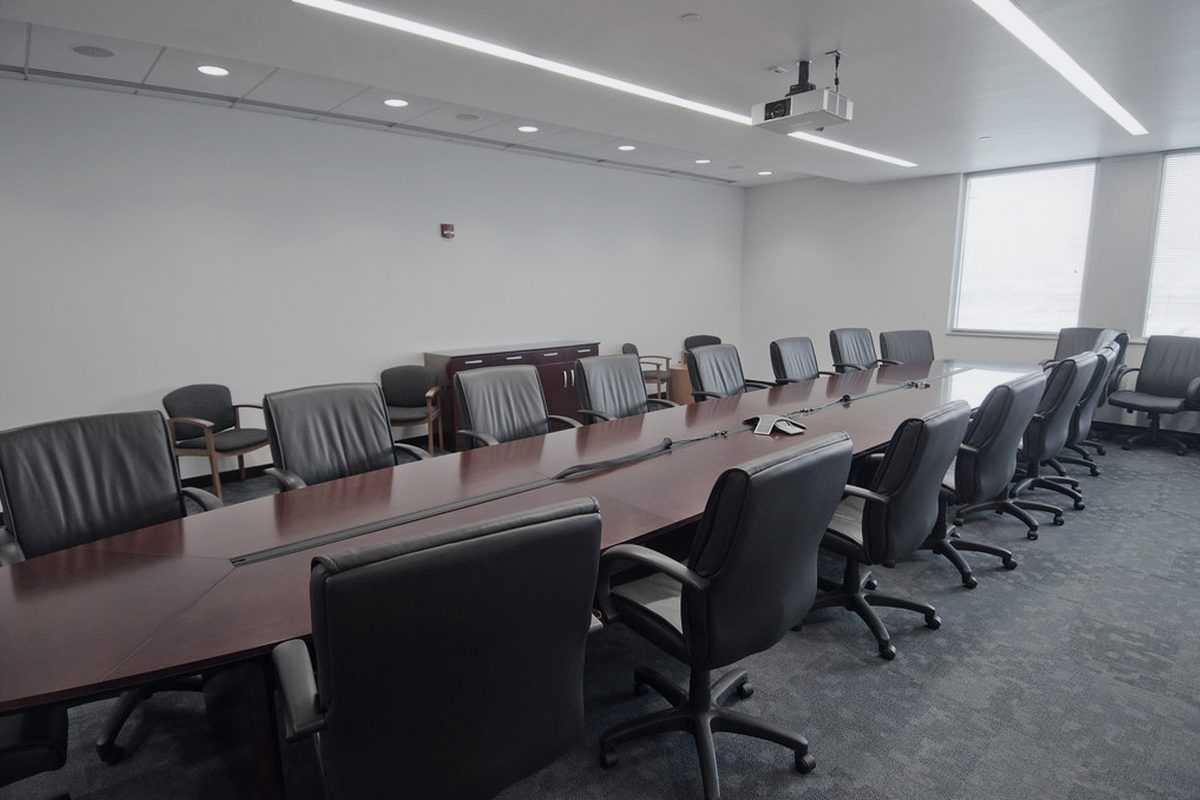 A long conference room arranged for a multi party proceeding